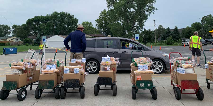 Carts full of food waiting for people to pick up in cars