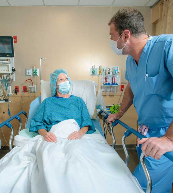 Doctor speaking with woman patient in hospital bed